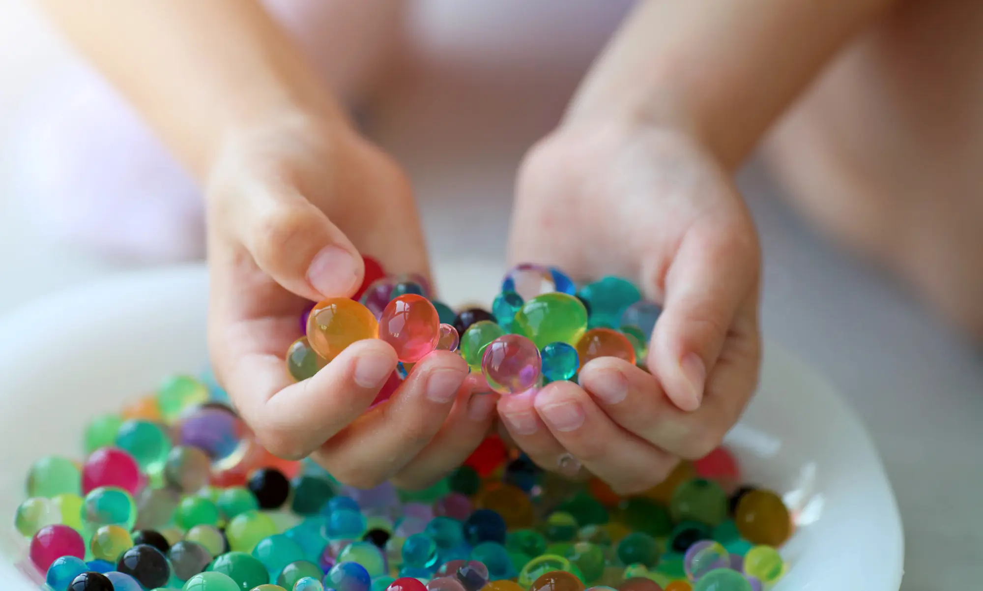 photo of hands holding water beads